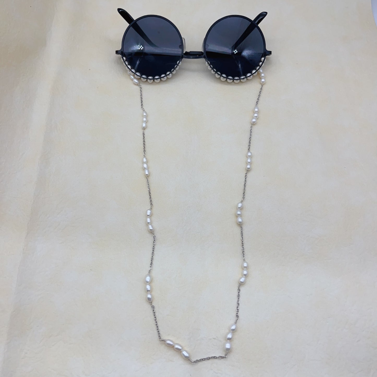 White pearls and black sunglasses