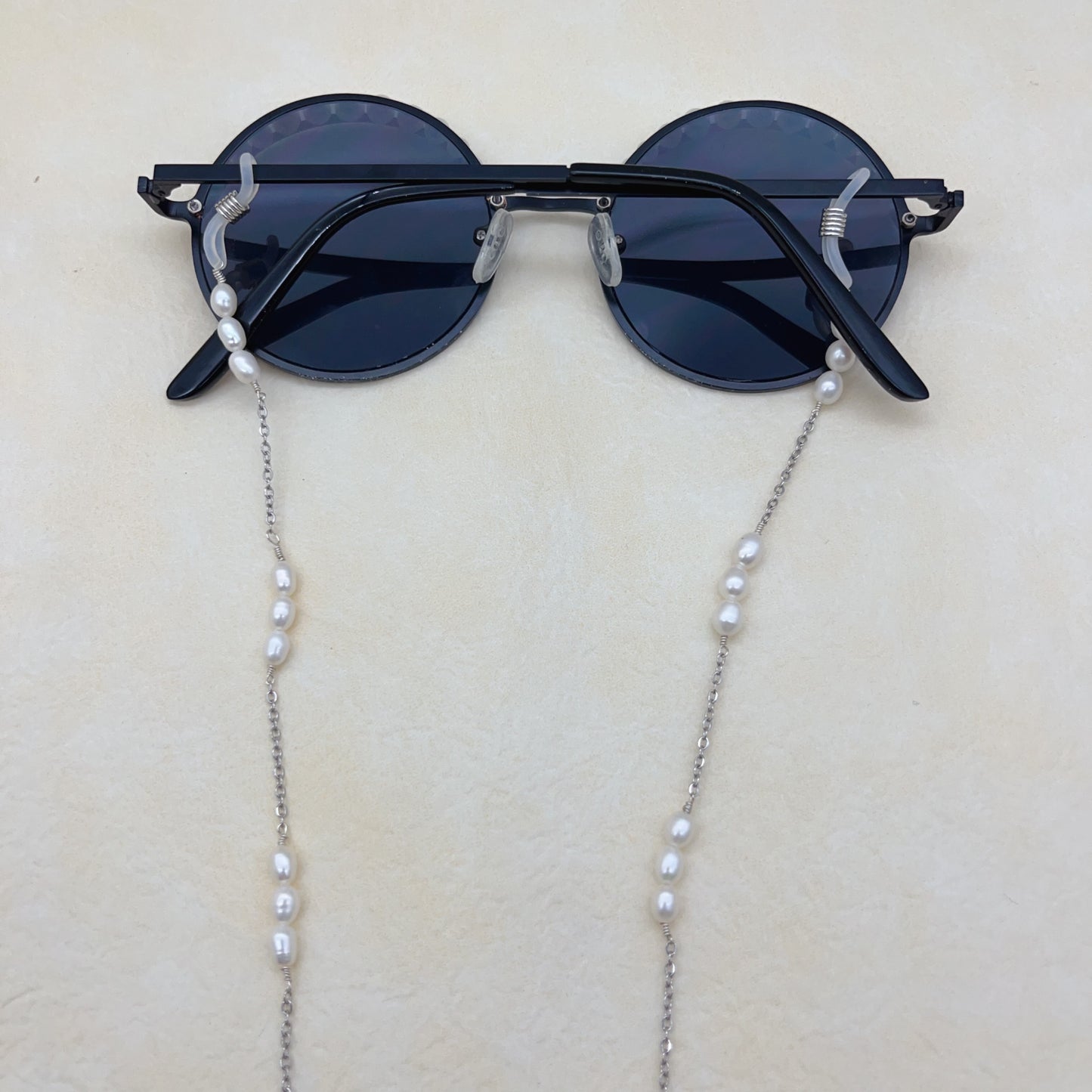 White pearls and black sunglasses